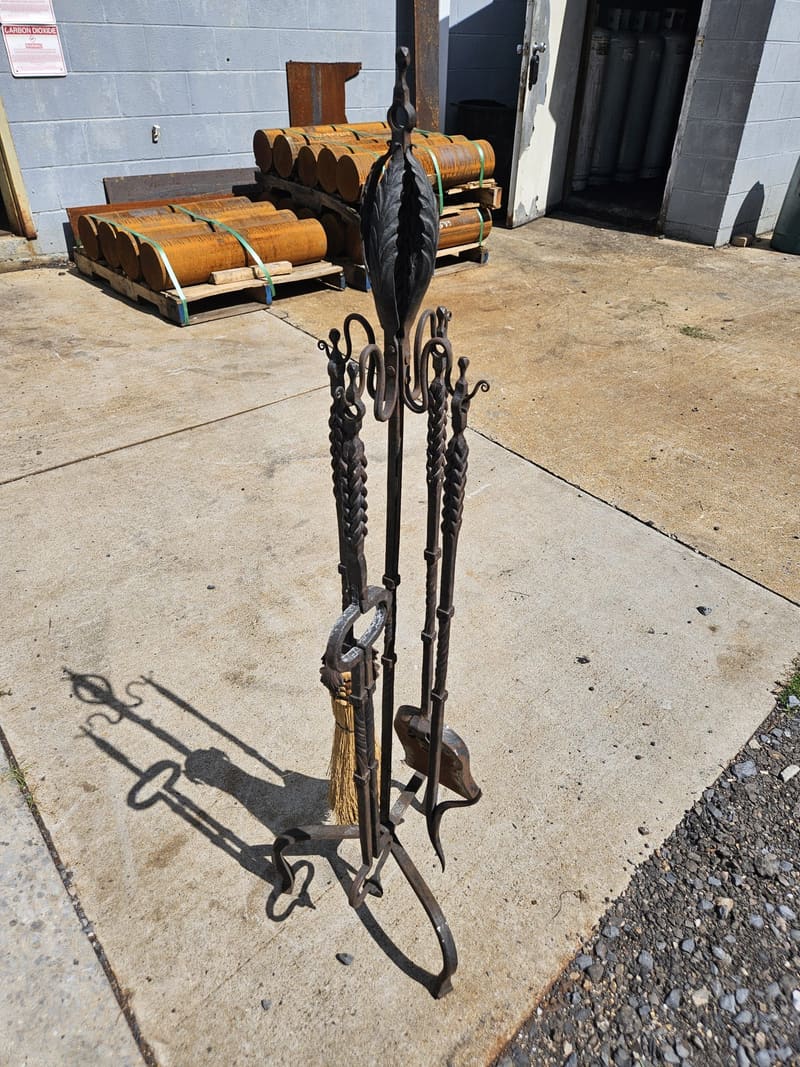 A forged five piece fireplace set