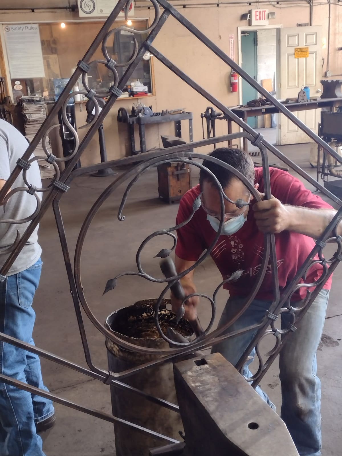 A student forging a large scroll in the VIB shop
